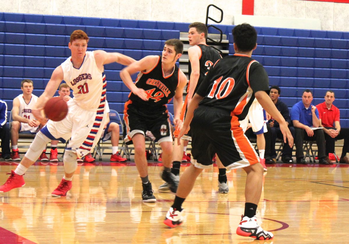 Cory Evak (20) drives to the basketball in a game against Greenville Colleges junior varsity team.